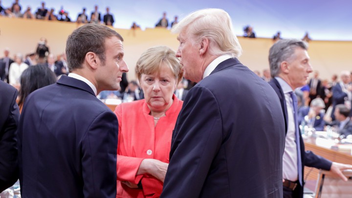 French President Emmanuel Macron, German Chancellor Angela Merkel and U.S. President Trump talk with one another.