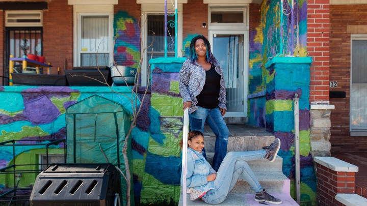 A woman and her daughter on the front steps of their home
