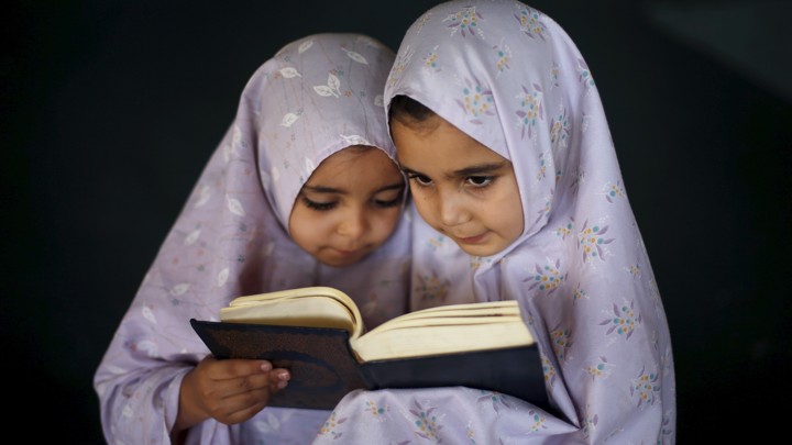 Two young girls reading the Quran