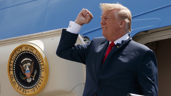President Trump raises his fist as he exits Air Force One.