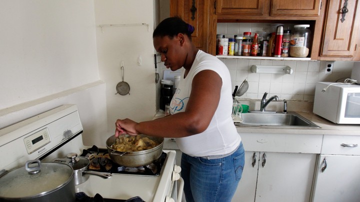 A woman prepares a meal on the stove.