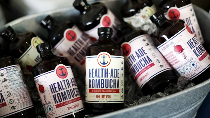 A bucket of glass bottles of kombucha over ice