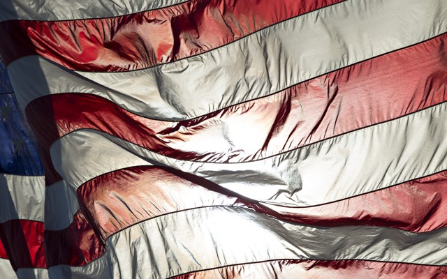 An American flag backlit with sunlight