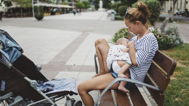 A baby is breastfed by a woman
