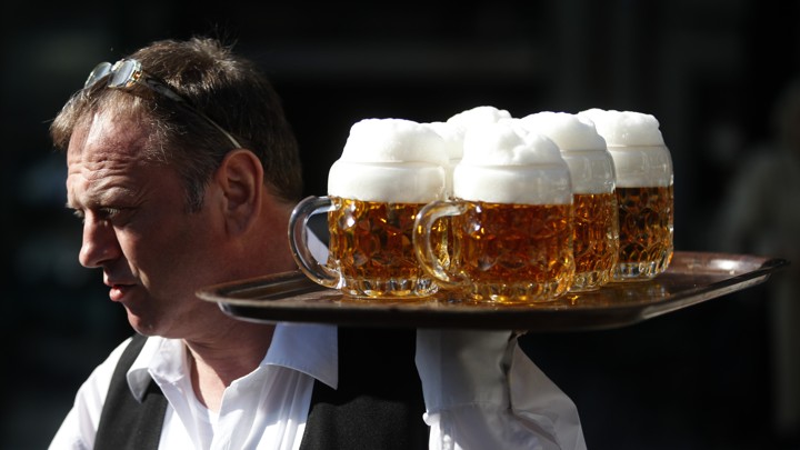 A waiter carries a tray of beers