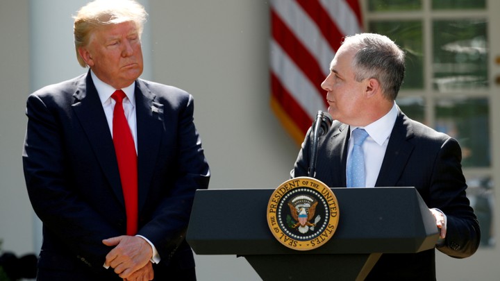 Scott Pruitt stands at a podium and addresses Donald Trump in the White House Rose Garden.