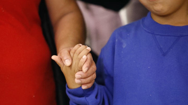 A mother and son hold hands