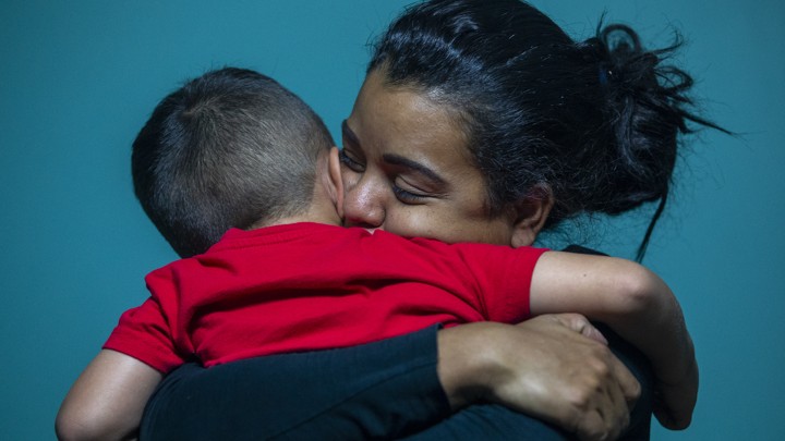 A woman hugs a small boy