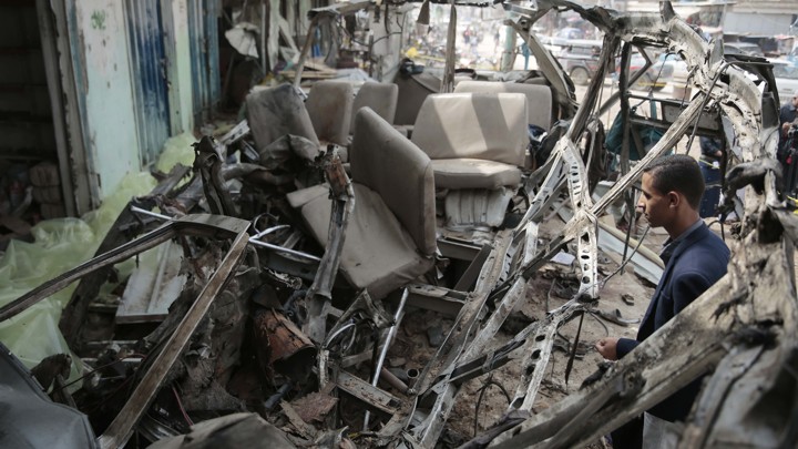 A man looks at the shell of a bus that had been destroyed in a Saudi air strike in Yemen.