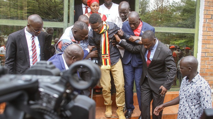 Bobi Wine walks with several other people supporting him.