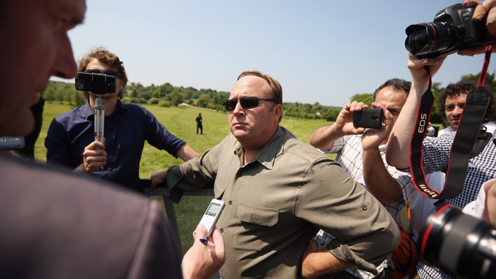 Alex Jones surrounded by people holding cameras