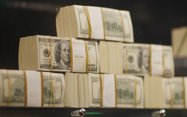 A stack of $100 bills on a scale