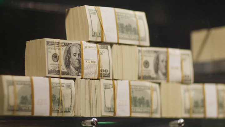 A stack of $100 bills on a scale