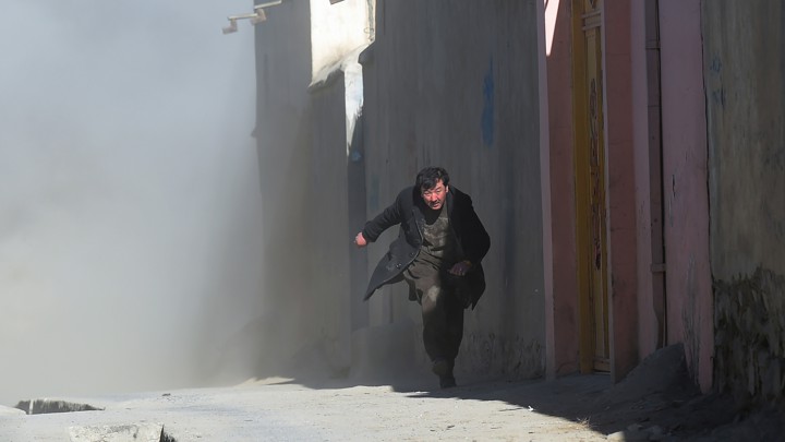 A man runs from dust that followed an attack on a Shiite cultural center in Kabul in 2017.