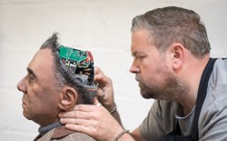 A human fixes a human-looking robot