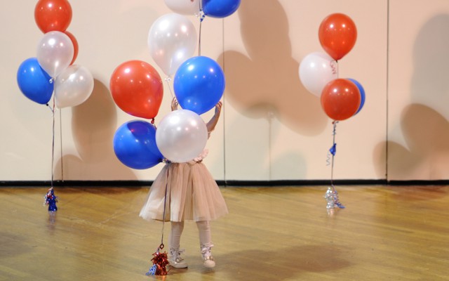 A little girl plays with balloons