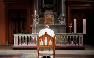 At a church in Ireland, Pope Francis sits and prays in front of a candle lit to remember victims of abuse.