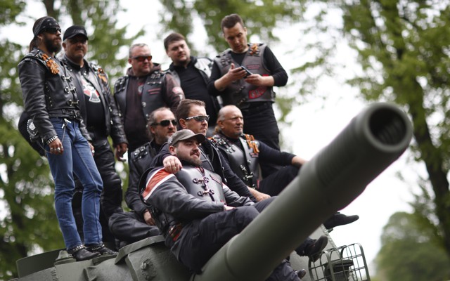 Members of the Night Wolves motorcycle group pose on top of a Red Army tank.
