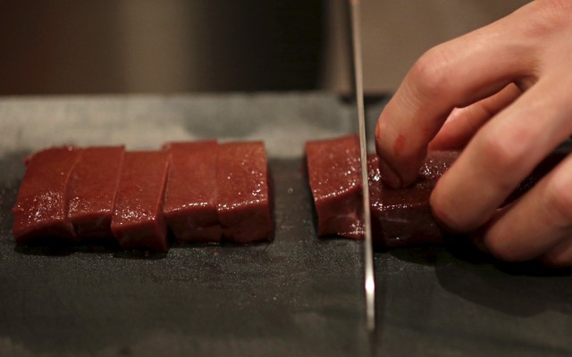A knife chops a line or raw beef.