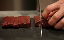 A knife chops a line or raw beef.