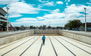 A man walks along the bottom of an empty public swimming pool near Cape Town.