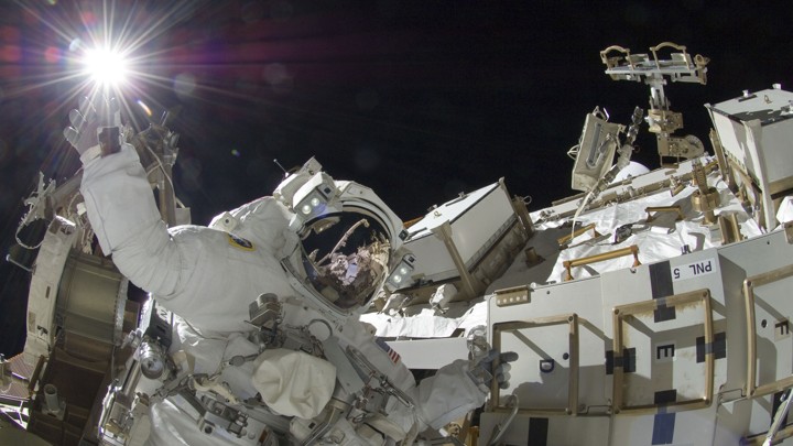 An astronaut works outside the International Space Station.