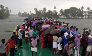 Volunteers stand under umbrellas on a boat that takes them to visit a flooded area in Kerala.