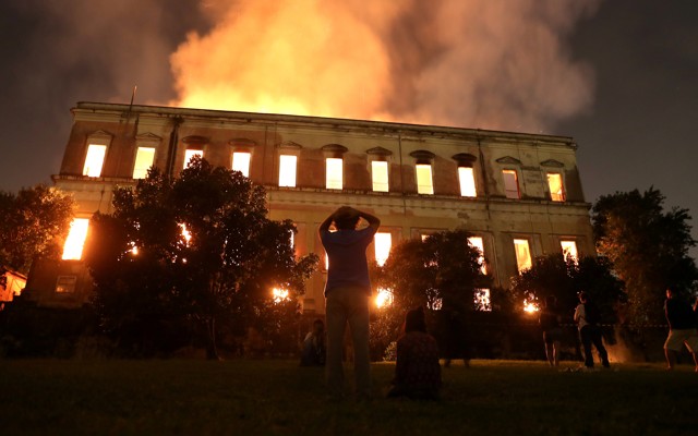 Outside spectators watch the National Museum in Rio de Janeiro burn.