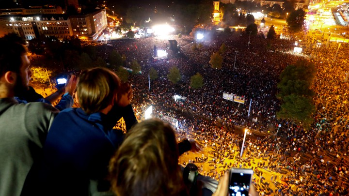 People photograph a crowd of concert-goers below