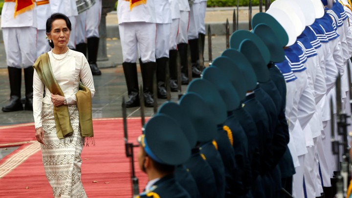 Aung San Suu Kyi walks past the honor guard at the presidential palace in Hanoi, Vietnam.