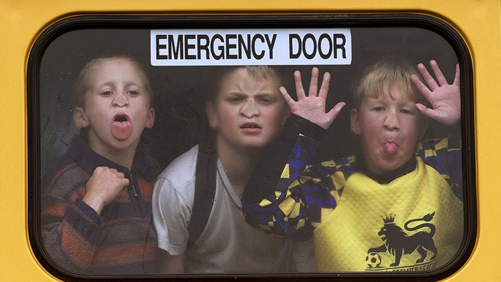 Students peer through the window of a school bus