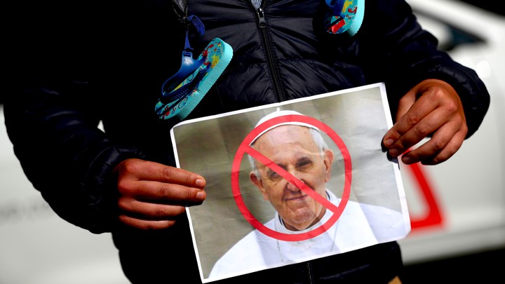 A protester in Dublin holds a picture of Pope Francis during a demonstration against clerical sex abuse.