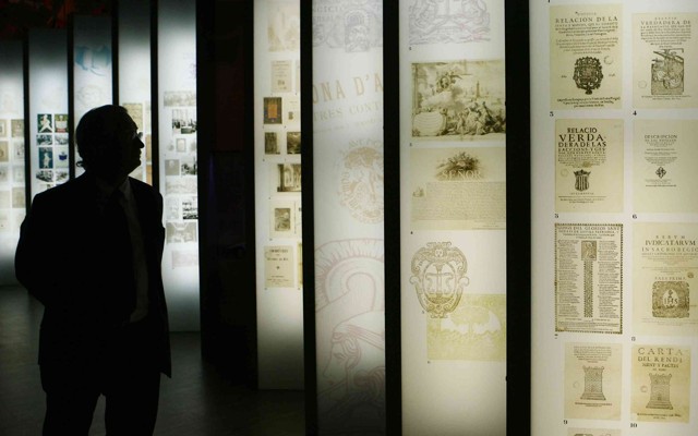 A man looks up at a series of informational panels.