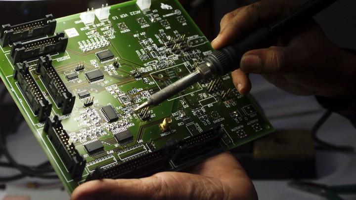 A technician works on a computer electronics component
