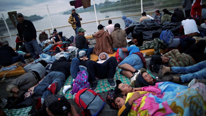Honduran migrants, part of the caravan trying to reach the U.S., wait to open the gate on the bridge that connects Mexico and Guatemala on October 20, 2018