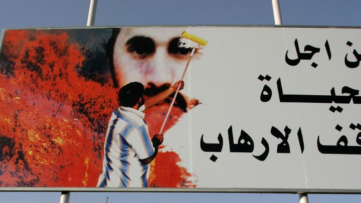 A poster in Baghdad depicts a man painting over a picture of Abu Musab al-Zarqawi.