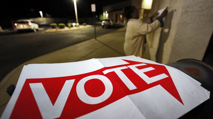 An election official hangs "Vote" signs outside a polling station in Phoenix, Arizona.