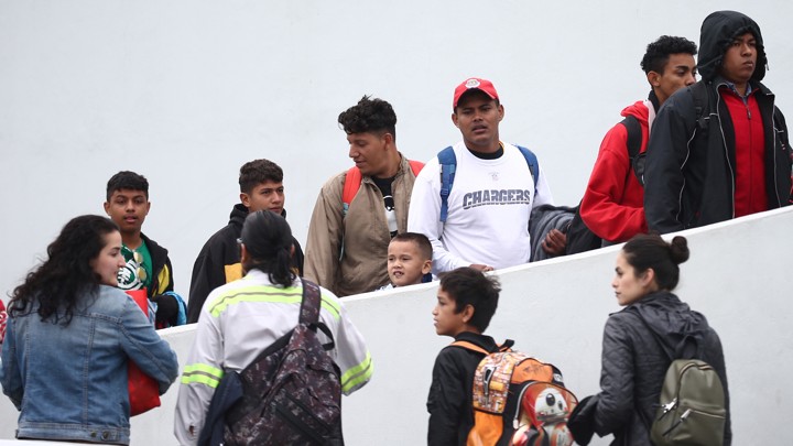 Members of a caravan of migrants enter the U.S. Customs and Border Protection facility where they are expected to apply for asylum, in Tijuana, Mexico, on May 2, 2018.