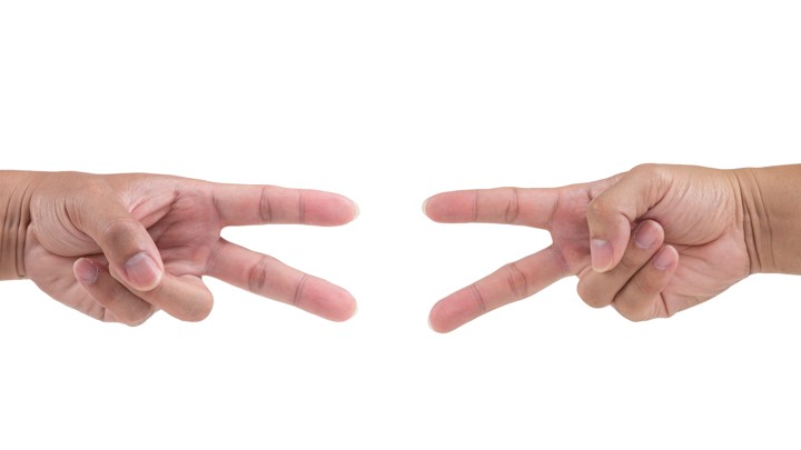 Two hands reaching out to snip