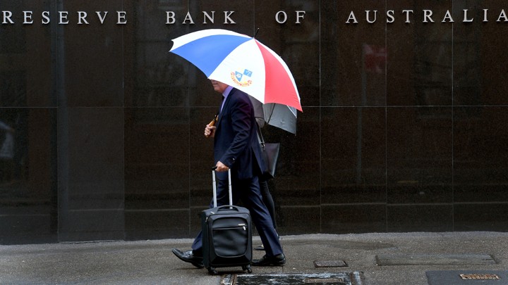 Two men walk past the Reserve Bank of Australia