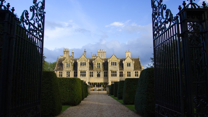 A picture of a large estate behind a set of gates