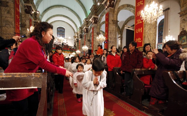 Chinese children walk down the aisle during Christmas Mass at a Catholic church in Beijing.