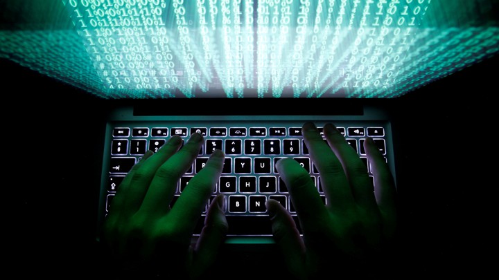 A man types on a laptop keyboard.