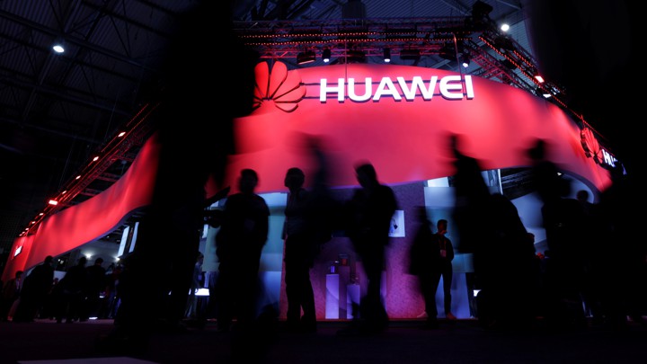Company trot past a Huawei stand at the 2017 Cellular World Congress in Barcelona, Spain.