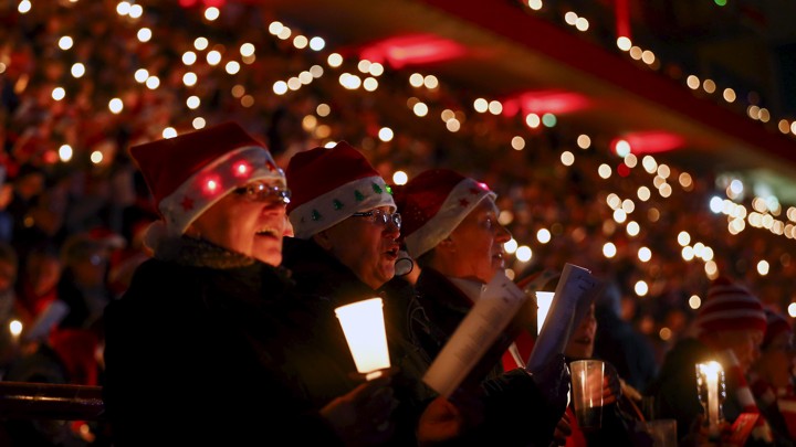 Christmas carolers wear Santa Claus hats