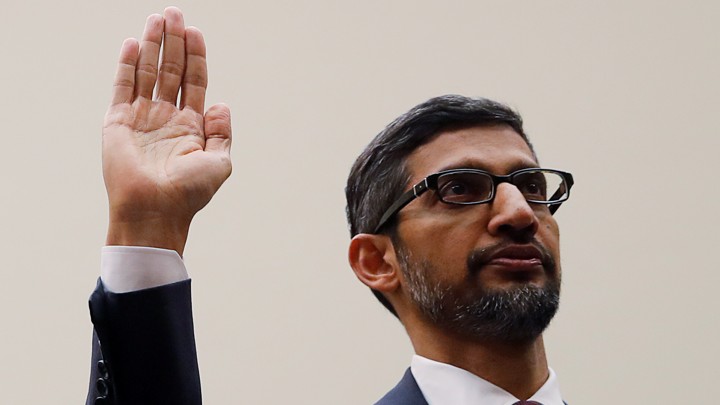 Sundar Pichai raises his right hand.