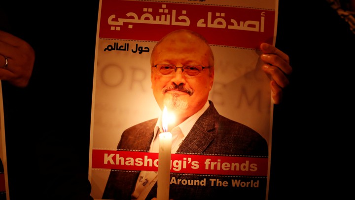 A demonstrator holds a poster with a picture of Jamal Khashoggi.