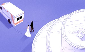A man and a woman walk away from a cake and toward and an ambulance