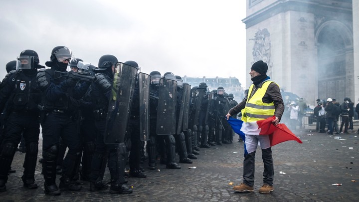 A protester stands in front of riot police at the Arc de Triomphe on January 12.
