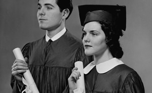 A man and a woman hold college diplomas